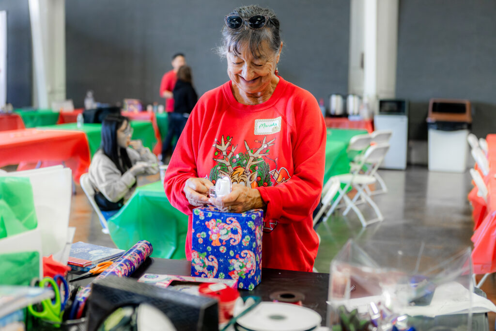 Adopt A Family volunteer wrapping gifts