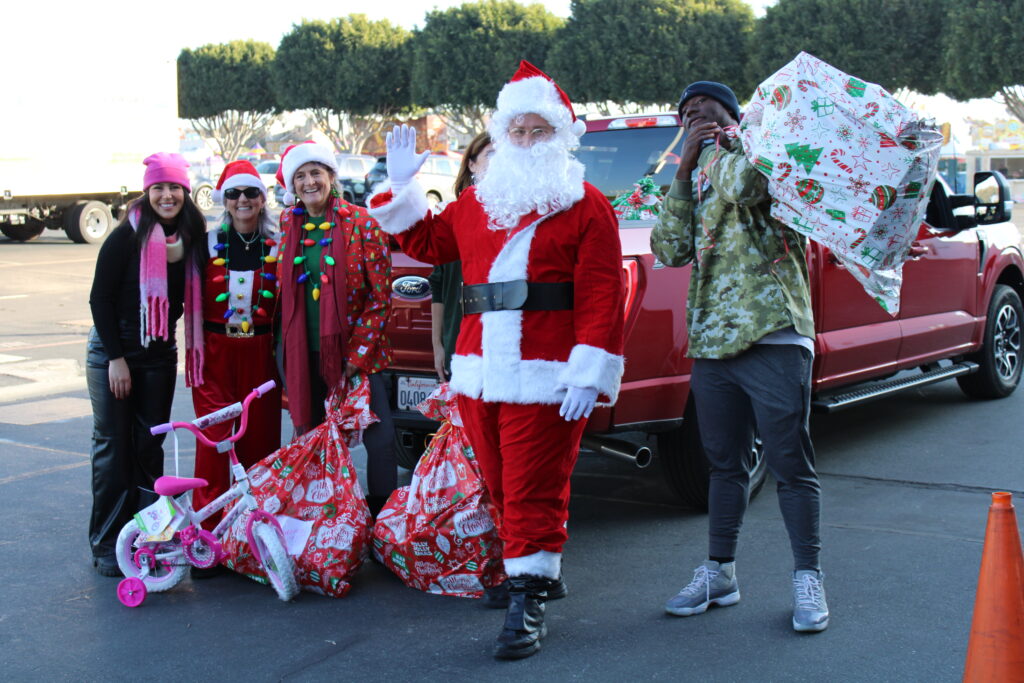 Santa and his helpers delivering gifts for Share Ourselves' Adopt A Family program